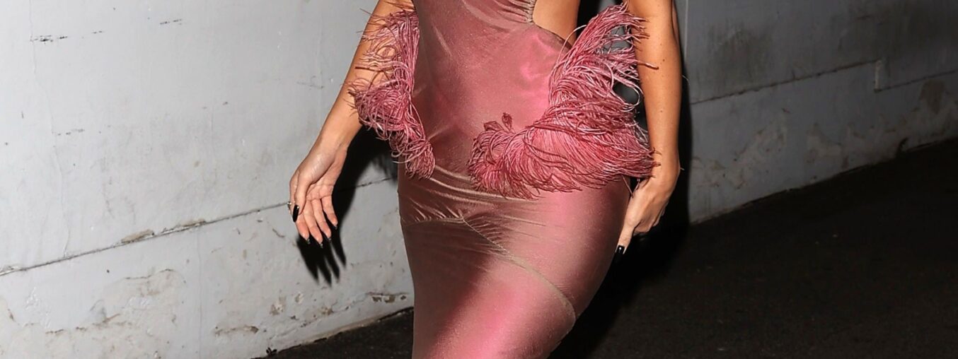 Kylie Jenner's festive look features pink feathers and a playful nod.